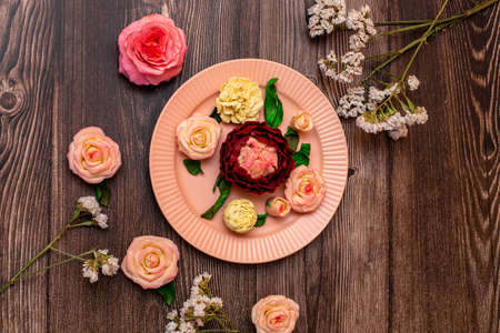 Chocolate pink roses, white roses, peonies on a background of dark wood.の写真素材