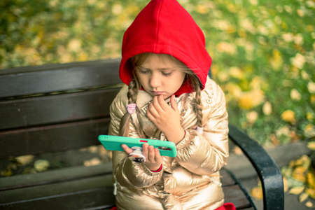A girl with a phone on the street.の写真素材