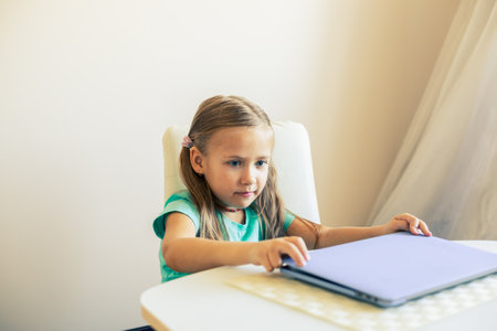 Little cute girl opens laptop to have video callの写真素材
