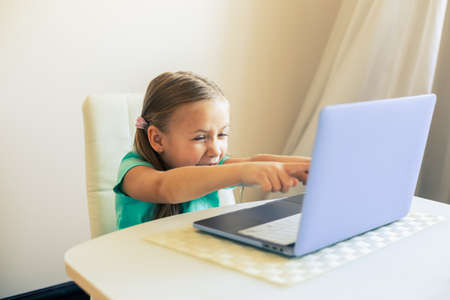 Little cute girl uses laptop to have video call