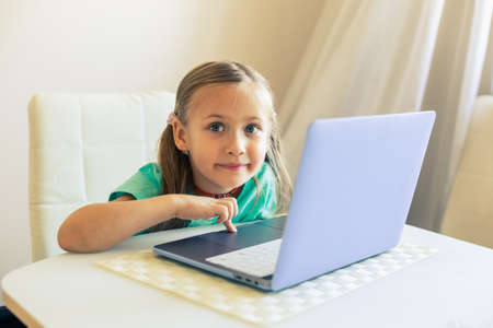 Little cute girl uses laptop to have video callの写真素材