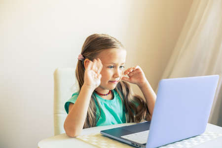 Little cute girl uses laptop to have video callの写真素材