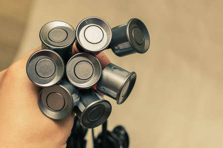 Bouquet of grey parking sensors with wires in a hand