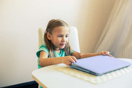 Little cute girl opens laptop to have video callの写真素材