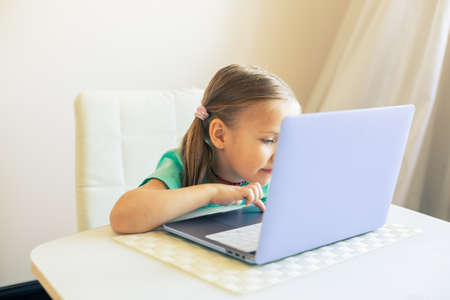 Little cute girl uses laptop to have video callの写真素材