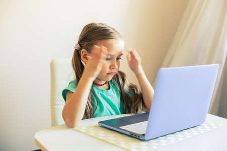 Little cute girl uses laptop to have video callの写真素材
