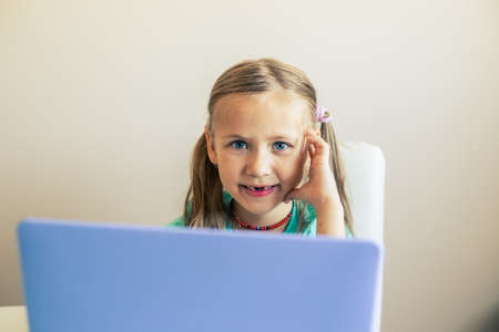 Little cute girl uses laptop to have video callの写真素材