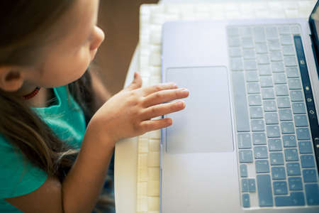 Little cute girl uses laptop to have video callの写真素材