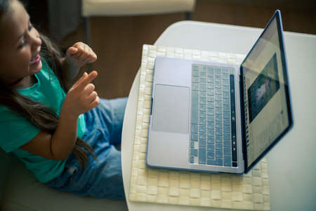 Little cute girl uses laptop to have video callの写真素材