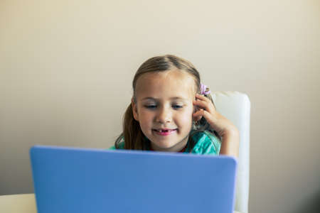 Little cute girl opens laptop to have video callの写真素材