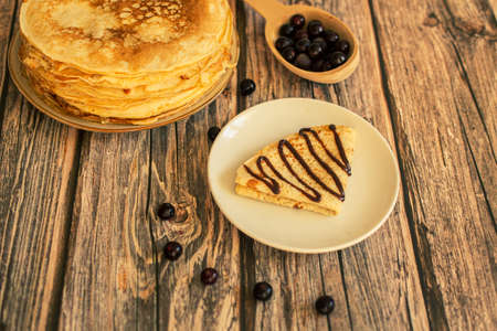 Delicious pancakes with chocolate sauce fresh blueberries on a rustic wooden table. Rustic brown...