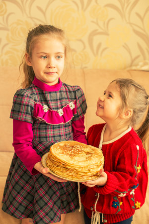 Happy little girls with pancakes.Two funny sistersの写真素材
