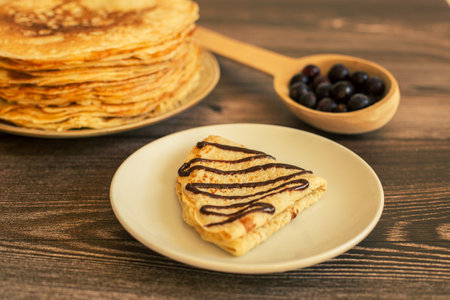 Delicious pancakes with chocolate sauce fresh blueberries on a rustic wooden table. Rustic brown table.の写真素材
