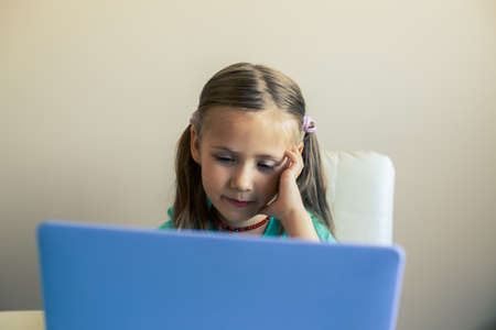 Little cute girl uses laptop to have video callの写真素材
