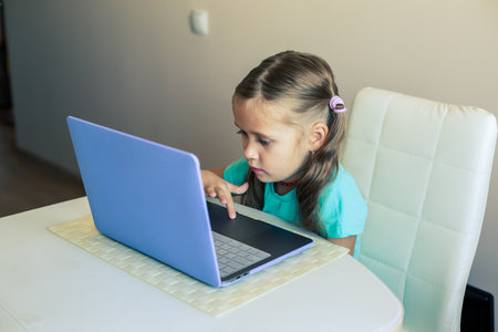 Little cute girl uses laptop to have video callの写真素材