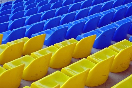 Blue and yellow empty stadium seatsの写真素材