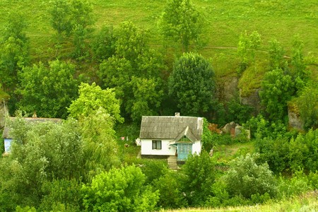 Summer day landscape with meadow and houseの写真素材
