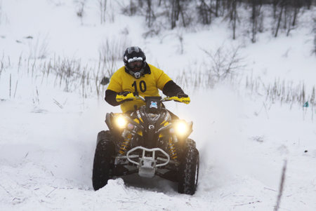 KYIV, UKRAINE - 13 FEBRUARY 2010: The quad bike's driver Roman Balykin (Kawasaki) rides over snow...