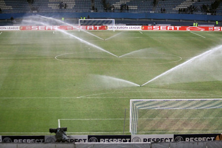 KYIV, UKRAINE - MARCH 10, 2011: Soccer field of Valeriy Lobanovskiy Stadium are watering after UEFA Europa League game FC Dynamo Kyiv vs FC Manchester City on March 10, 2011 in Kyiv, Ukraineのeditorial素材