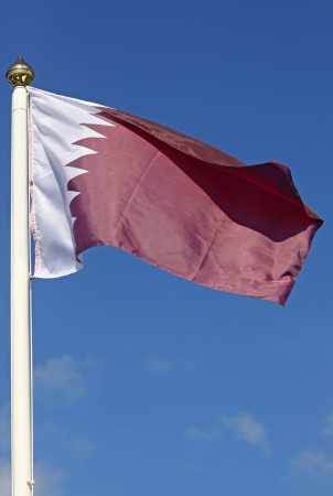 National flag of Qatar on blue sky backgroundの写真素材