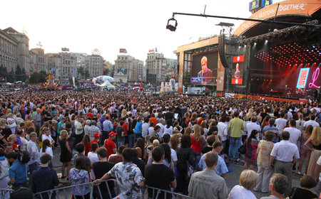 KYIV, UKRAINE - JUNE 30, 2012: People look on Sir Elton John performs onstage during charity Anti-AIDS concert at the Independence Square on June 30, 2012 in Kyiv, Ukraineのeditorial素材