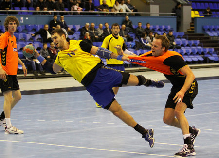 KYIV, UKRAINE - APRIL 2, 2013: Dmytro Doroshchuk of Ukraine (in yellow) attack the net during handball EHF EURO 2014 qualification game against Netherlands on April 2, 2013 in Kyiv, Ukraineのeditorial素材