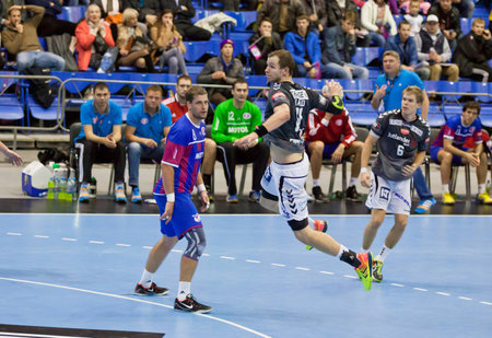 KYIV, UKRAINE - OCTOBER 18, 2014: Simon Hald Jensen of Aalborg (C) attacks during European Handball Champions League game against Motorのeditorial素材