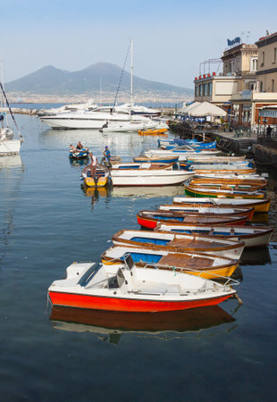 NAPLES, ITALY - MAY 6, 2015: Small harbour near Castel dell'Ovo in Naples, Italy. Gulf of Naples and Volcano Vusuvius on the backgroundのeditorial素材