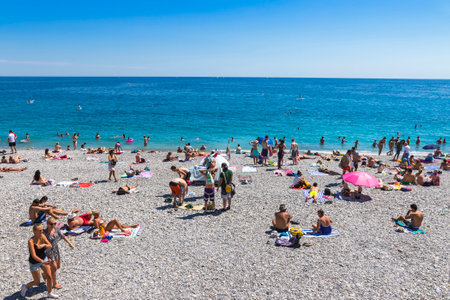 NICE, FRANCE - JUNE 22, 2016: Crowded municipal beach near Promenade des Anglais in City of Nice, Cote D'azur, Mediterranean sea, Franceのeditorial素材