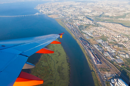 LISBON, PORTUGAL - JUNE 14, 2013: Airbus A320 operated by EasyJet (flight number EZY 7603) flights over Lisbon city. Aerial view through the airplane windowのeditorial素材
