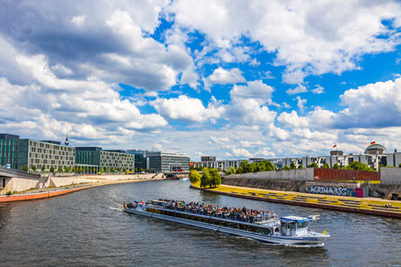 BERLIN, GERMANY - JULY 1, 2014: Sightseeing boats on the river Spree in a sunny summer day in center of Berlin city, Germany. Spreebogenpark on the right. TV-tower and Bundestag roof on the backgroundのeditorial素材