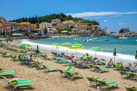 Milocer, Montenegro - June 20, 2010: Picturesque summer view of Adriatic seacoast in Budva Riviera. Przno beach, Milocer, Montenegro. Sun beds and umbrellas on the beachのeditorial素材