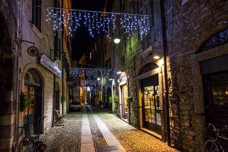 COMO, ITALY - DECEMBER 2, 2016: Night view of Via Vitani street in Como Old Town, Lombardy, Italy. Como is the 4th most visited city in Lombardy after Milan, Bergamo and Bresciaのeditorial素材