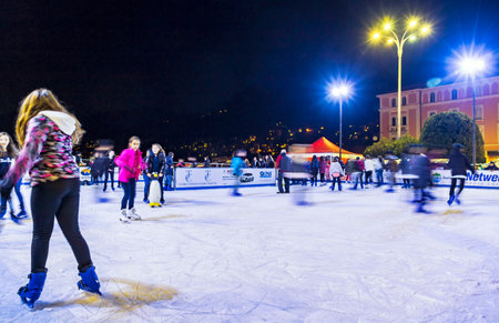 COMO, ITALY - DECEMBER 2, 2016: Ice skaters having fun on skating rink at annual traditional Christmas fair on Piazza Cavour in center of Como old town, Lombardy, Italyのeditorial素材