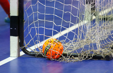 KYIV, UKRAINE - JANUARY 29, 2017: Orange Futsal ball in the net during friendly Futsal match Ukraine v Spain at Palats of Sports in Kyiv, Ukraineのeditorial素材
