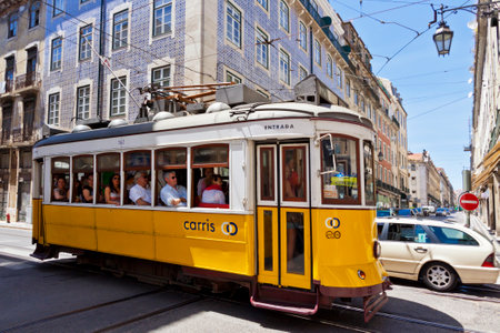 LISBON, PORTUGAL - JUNE 22, 2013: Yellow tram of the Route #28 on the street of Lisbon. It is one of the most popular routes by tourists. Lisbon tramway network operates since 1873のeditorial素材
