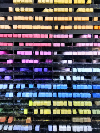 Colourful pieces of pastel chalks on the shelfの写真素材
