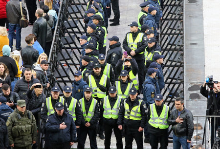 Kyiv, Ukraine - April 19, 2019: Policemen and securities listen to the national anthem during the...