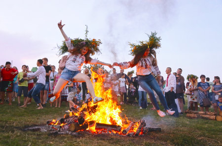 Kyiv, Ukraine - July 6, 2018: Young people jump over the flames of bonfire during the traditional Slavic celebration of Ivana Kupala holiday in Pirogovo open-air ukrainian folk museum in Kyiv, Ukraineのeditorial素材