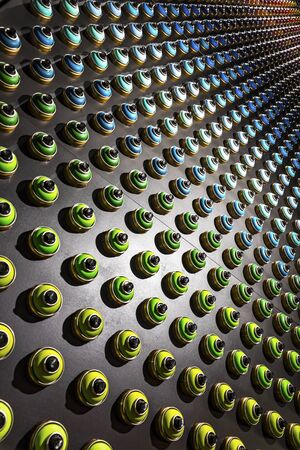 Rows of color paint spray cans placed on a black wall. Abstract colour palette