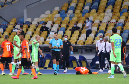KYIV, UKRAINE - AUGUST 5, 2020: Referee Ivan Kruzliak (SVK) shows yellow card to player during the UEFA Europa League game Shakhtar Donetsk v VfL Wolfsburg at NSC Olimpiyskyi stadium in Kyivのeditorial素材