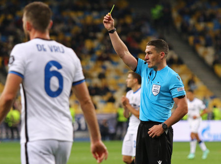 KYIV, UKRAINE - SEPTEMBER 28, 2021: Referee Istvan Kovacs (ROU) shows yellow card during the UEFA Champions League game Shakhtar Donetsk v Internazionale at NSC Olimpiyskyi stadium in Kyivのeditorial素材