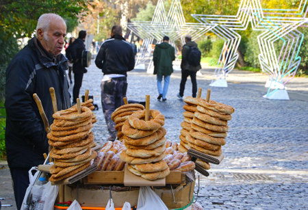 Athens, Greece - December 21, 2019: Unknown street vendor selling traditional Greek crispy baked...