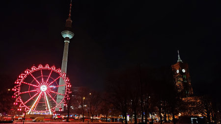 Berlin, Germany - Nov 30, 2023: 50-metre-high panoramic Ferris wheel on Christmas market (Berliner Weihnachtszeit) at Rotes Rathaus in Berlin. TV Tower (Fernsehturm) and Rotes Rathaus on backgroundのeditorial素材