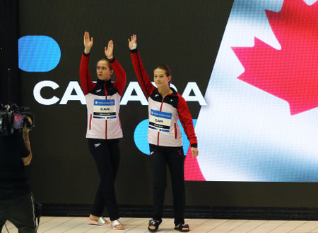Berlin, Germany - March 23, 2024: Caeli McKAY and Kate MILLER of Canada greet the fans during Women's Synchronized 10m Platform Final of the World Aquatics Diving World Cup 2024 in Berlin, Germanyのeditorial素材