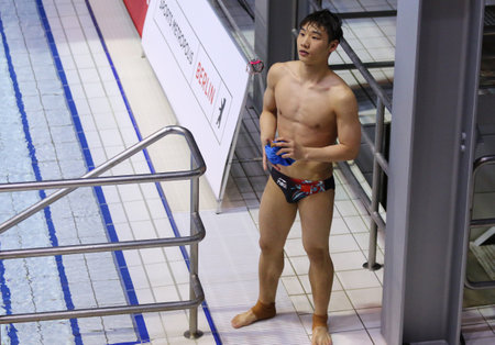 Berlin, Germany - March 24, 2024: Diver Jiuyuan ZHENG of China reacts after his jump during the Men's 3m Springboard Final of the World Aquatics Diving World Cup 2024 in Berlinのeditorial素材