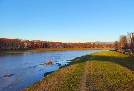 Scenic spring view of Uzhhorod city and Uzh river, Transcarpathia, Ukraine. Dawn riverbank view with greenery and historic buildings on the backgroundの写真素材