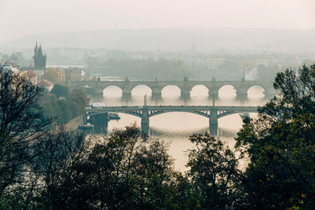 Panoramic calm and misty morning view of Prague bridges over the Vltava river with historic cityscape, Chechiaの写真素材