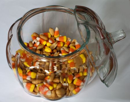 Pumkin candy dish filled with peanuts and candy cornの写真素材