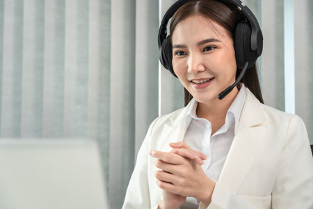 Female call center provides information to a customer calling for help, Contact us, Service with a beautiful and friendly voice, Long distance communication, Talk using headphones or headsets.の写真素材